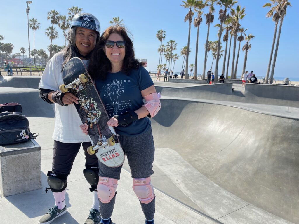 Two female skateboarders at the Venice Beach skatepark in California.