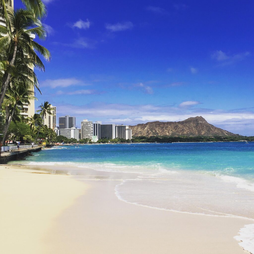 View of Diamond Head Monument and Waikiki beach with the yellow sand turquoise ocean. 