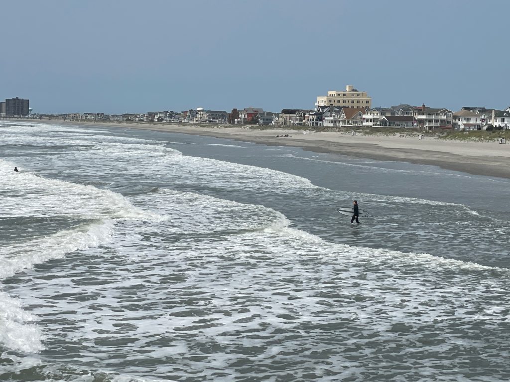 View of Ventnor, NJ from the fishing pier with houses and the shoreline with the ocean in the foregound. 