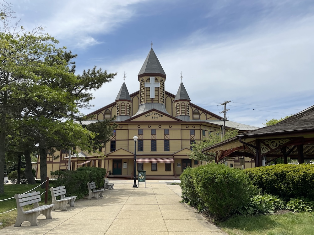 Photo of the Great Auditorium in Ocean Grove, NJ with benches and a park in front.